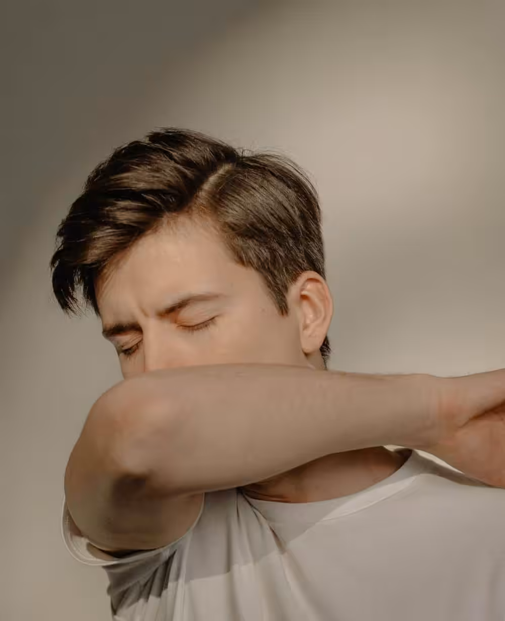 Man coughing into his elbow