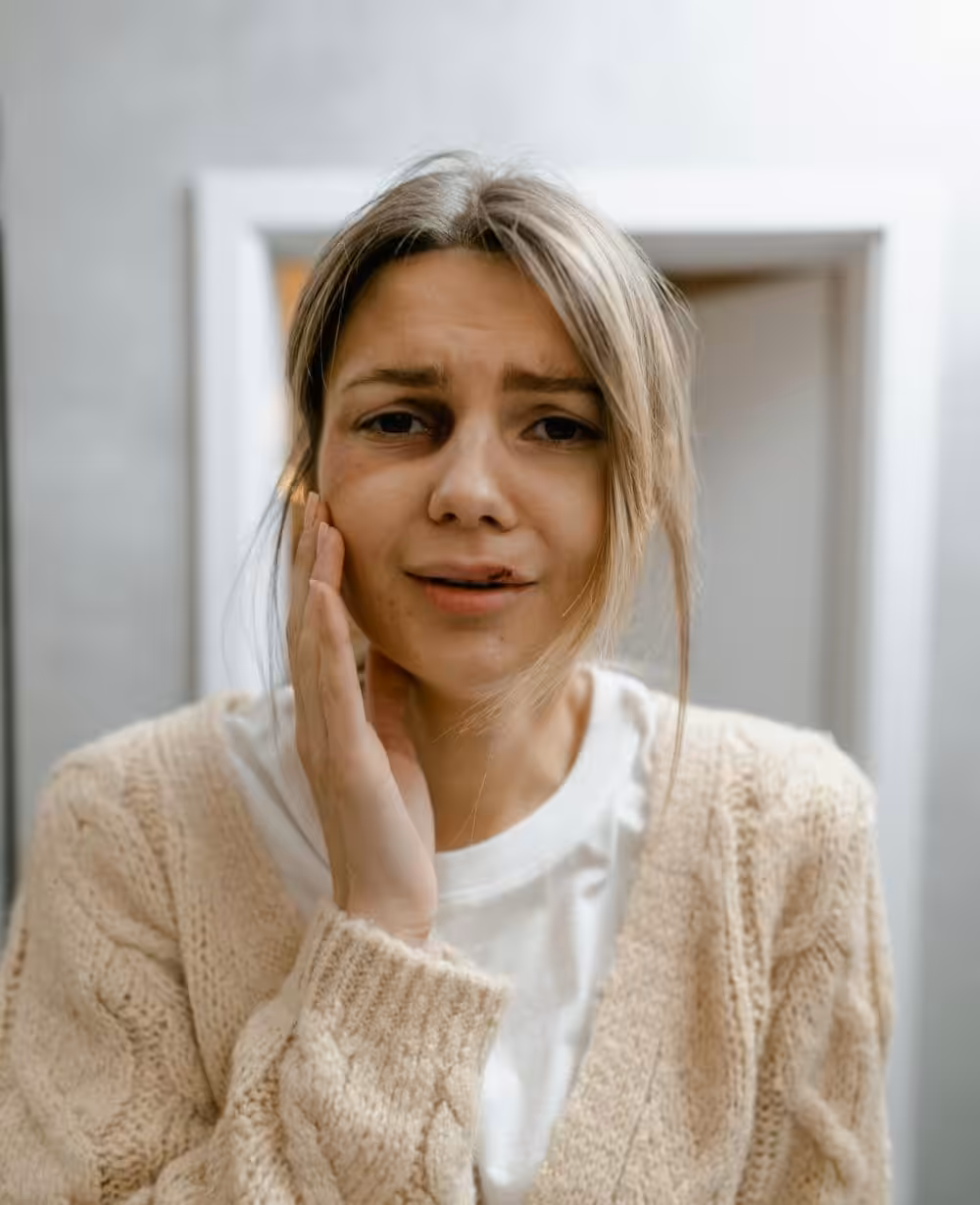 Woman holding side of face illustrating recovery and healing