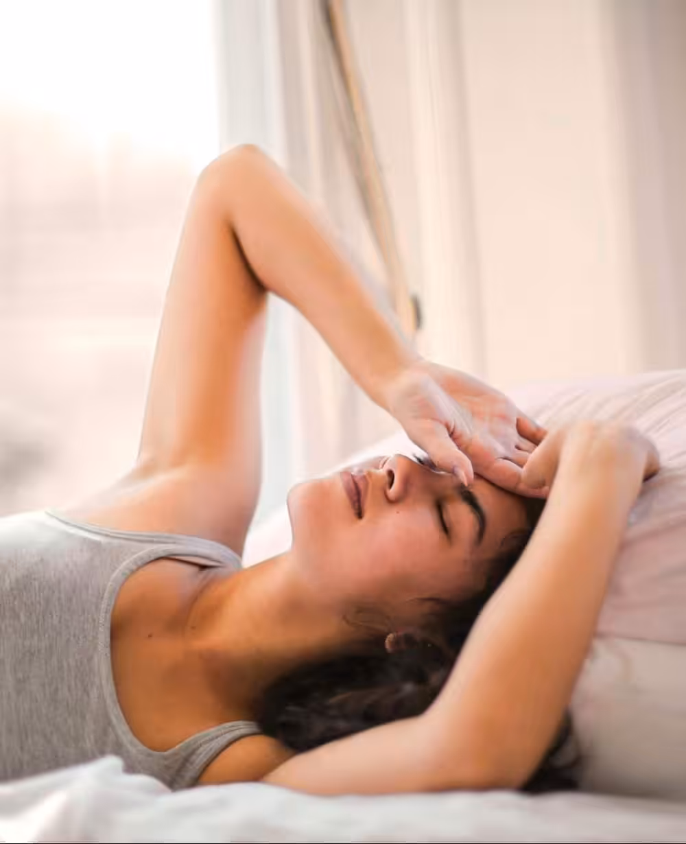 Woman in bed experiencing sleep and recovery issues